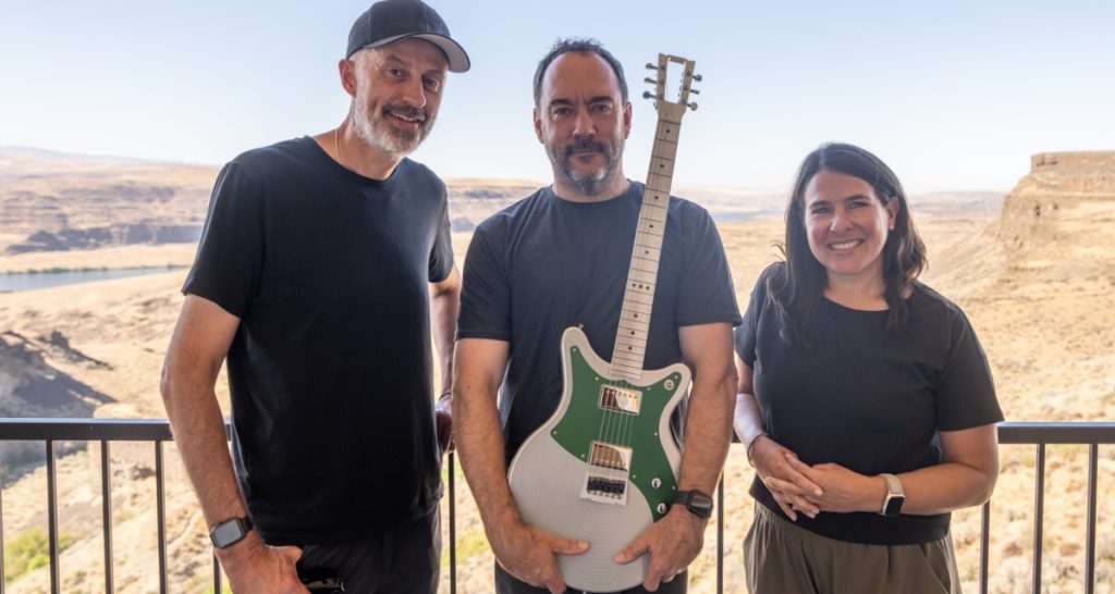 Three musicians posed with guitars