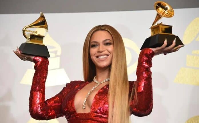 Beyoncé triumphantly raises Grammy awards