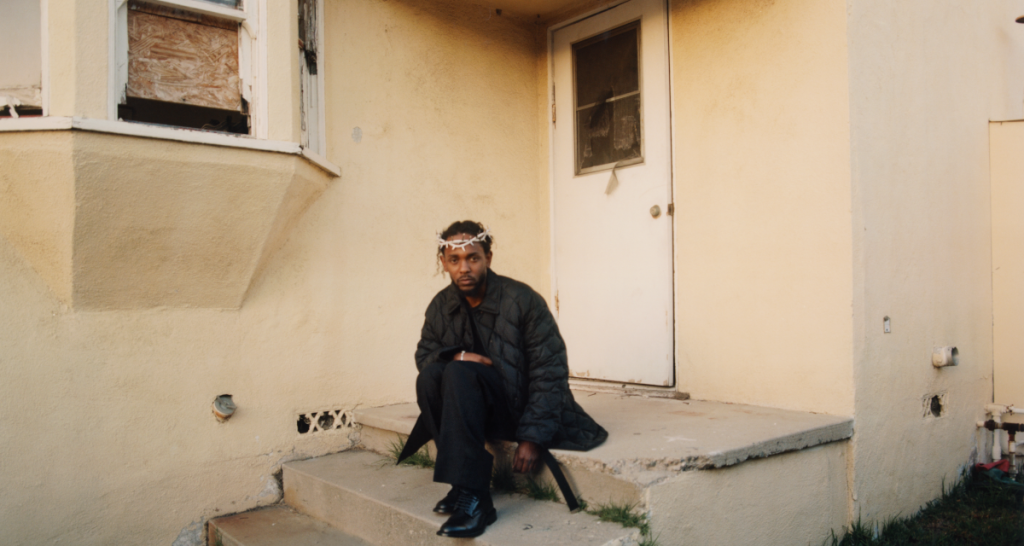 Kendrick Lamar seated on stone steps