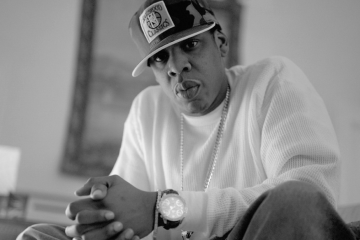 Jay-Z clasping hands, serious expression