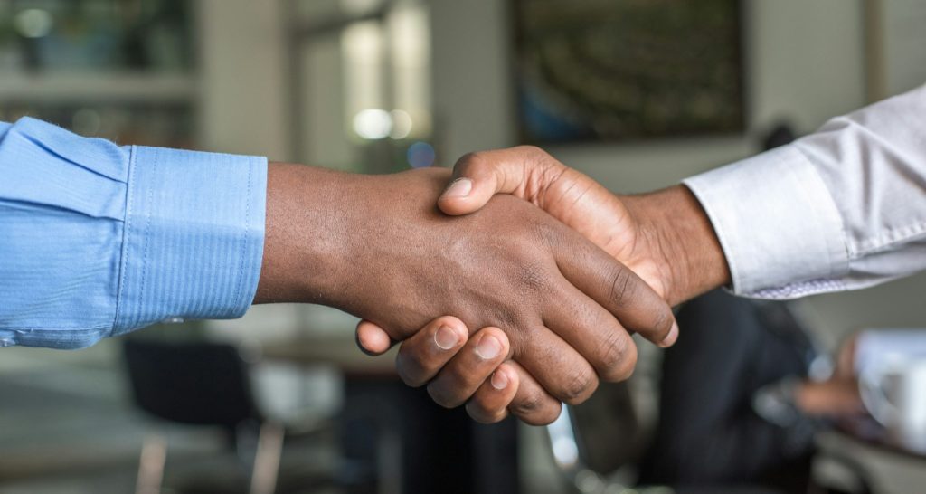 Business handshake on blue background