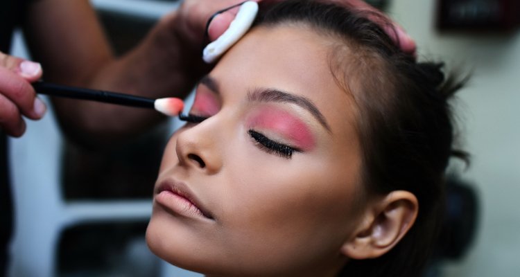 Woman getting cosmetics applied