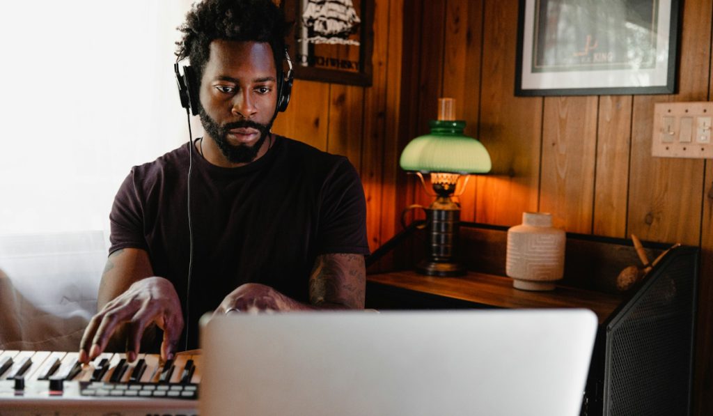 Musician using laptop and digital keyboard