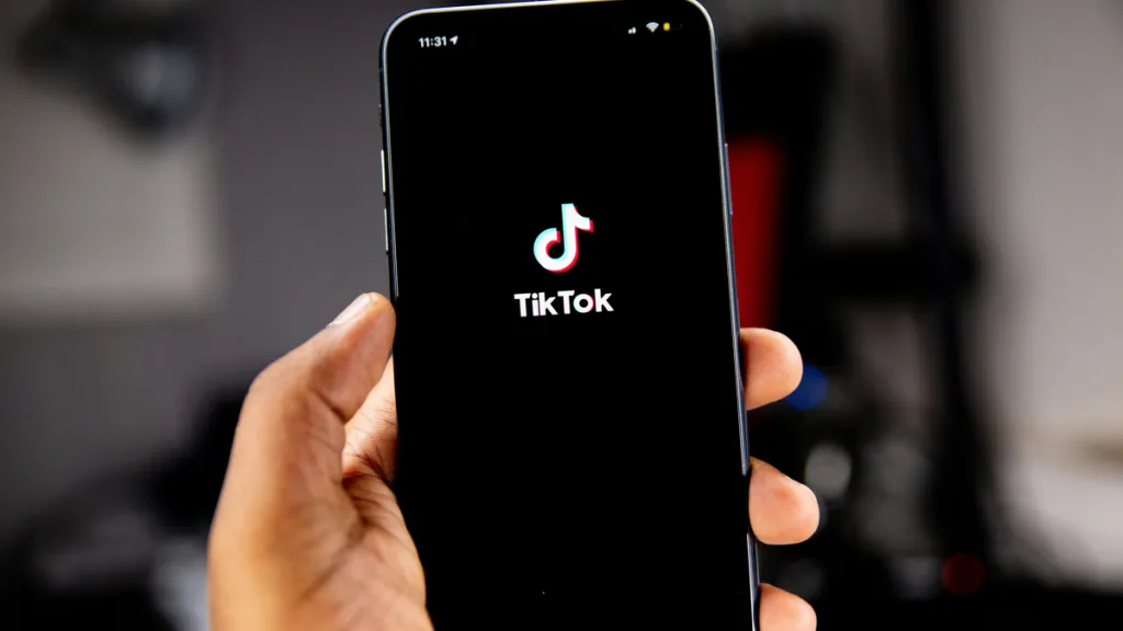 Hand holding phone displaying TikTok